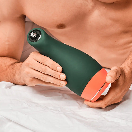 Homme torse nue et allongé sur un lit tenant entre ses mains le masturbateur Elvio de Mon Amour